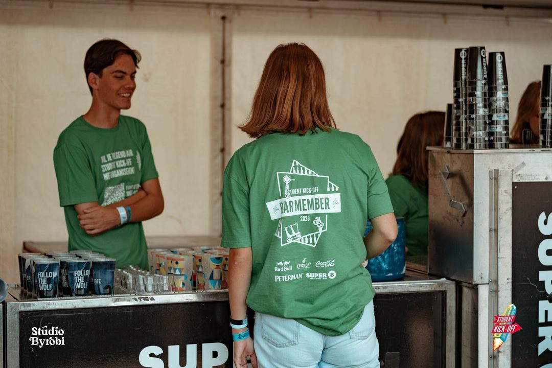 barmedewerkers in bedrukte groene t-shirts tijdens event